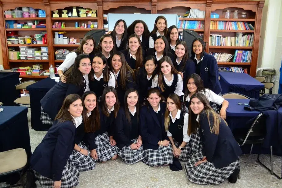 Grupo de estudiantes del Instituto Cumbres reunidas en la biblioteca escolar para foto de clase